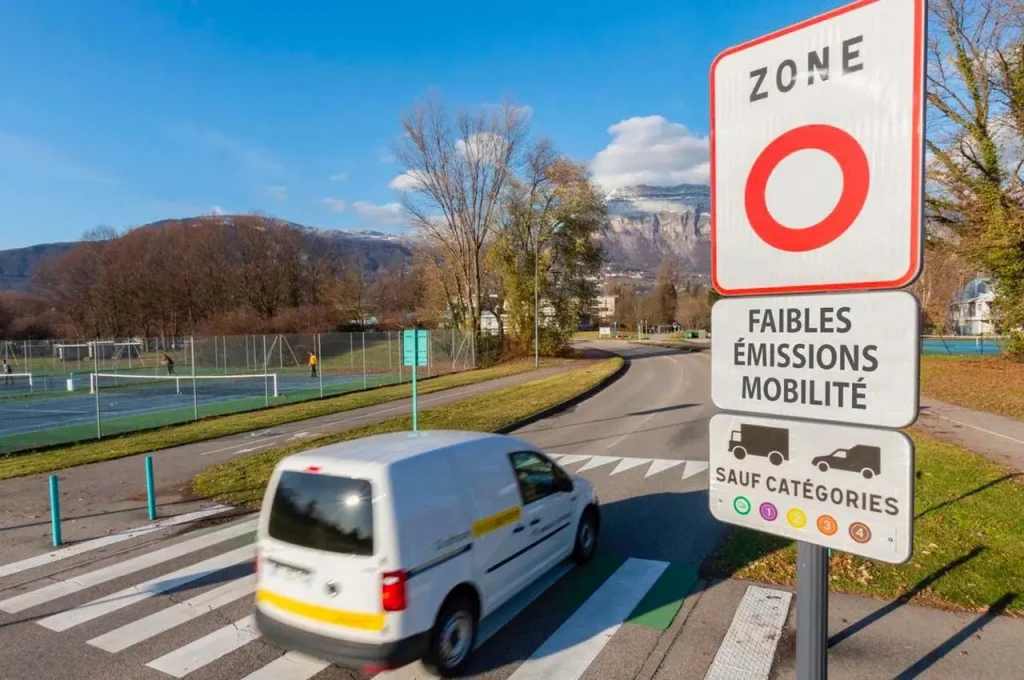 Un panneau ZFE à l'entrée d'une ville avec une fourgonette.