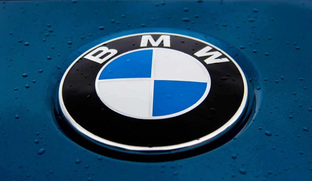 Le logo BMW sur un capot, avec quelques gouttes de pluie.